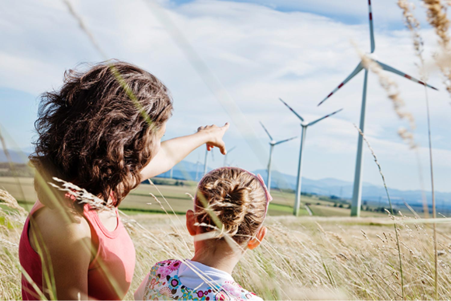 Mutter mit Kind in der Nähe von Windrädern